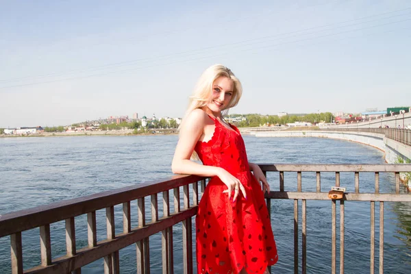 Chica joven en vestido rojo corto en el terraplén del río — Foto de Stock