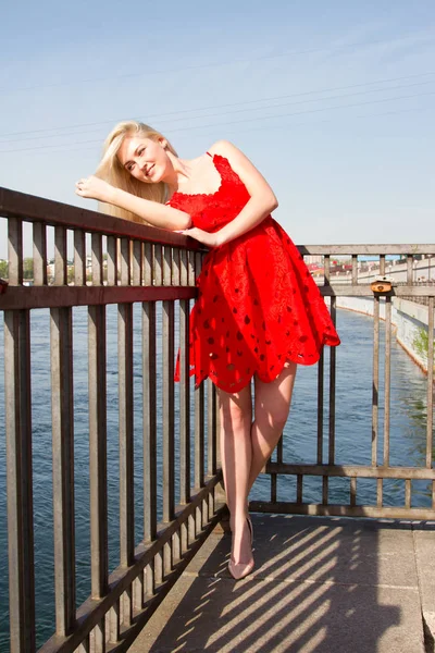 Young girl in short red dress on the river embankment — Stock Photo, Image