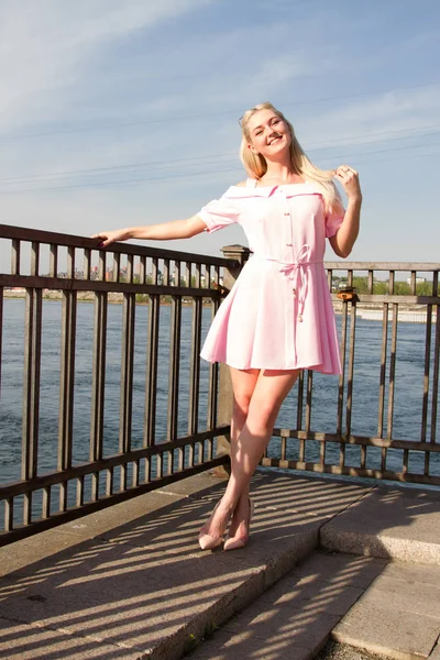 Jong meisje in korte jurk op de dijk van de rivier — Stockfoto