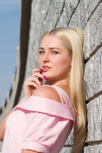 Blondine mit blauen Augen steht an der Granitwand — Stockfoto