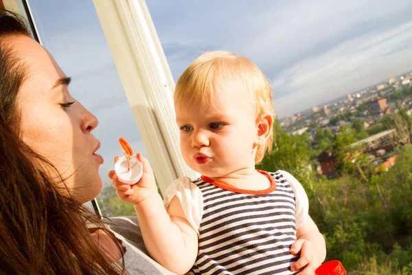 Mom and her baby let the soap balls from the balcony — Stock Photo, Image
