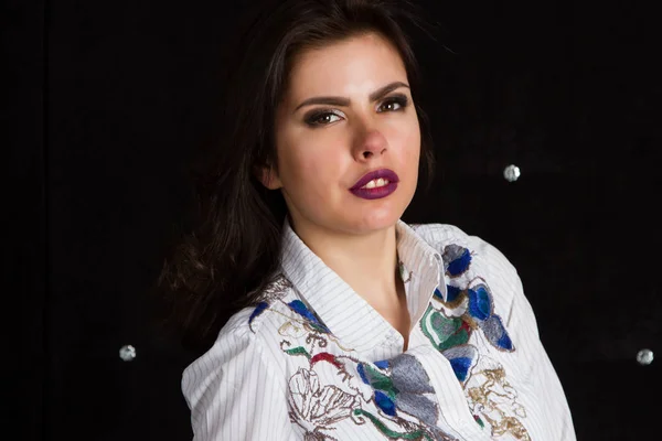 Brunette with bright make-up on a black background. Studio portrait. — Stock Photo, Image