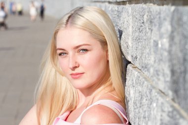 Granit duvarının yakınında pembe elbiseli genç kız