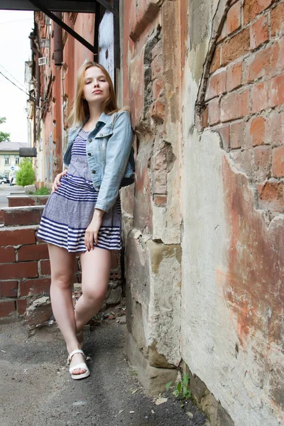Jong meisje bij de ingang van de oude bakstenen huis — Stockfoto