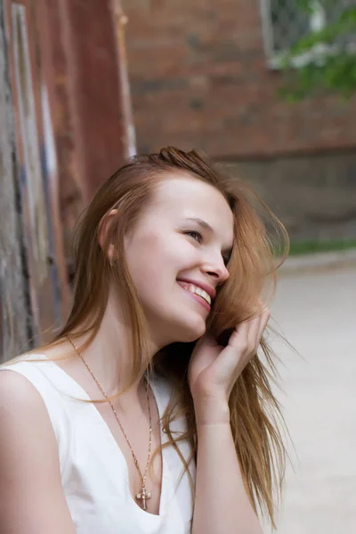 Red-haired girl in a dress on the background of a shabby wall — Stock Photo, Image