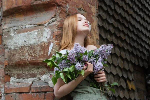 Chica con el pelo rojo está sosteniendo un ramo de lilas —  Fotos de Stock
