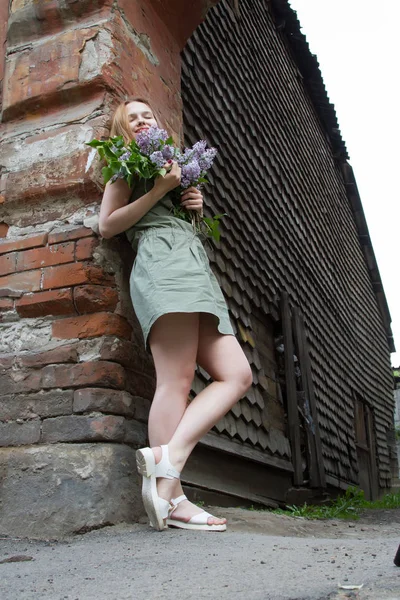 Chica con el pelo rojo está sosteniendo un ramo de lilas — Foto de Stock