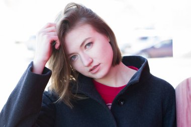 Kız bir ceket tarafından kırmızı kalkan duruyor