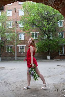 Leylak bir buket ile kısa kırmızı elbiseli kız