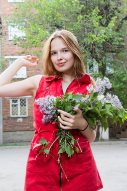 Leylak bir buket ile kısa kırmızı elbiseli kız