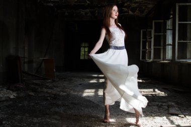 Beyaz bir elbise içinde gelin yanmış bir evin salonunda dans ediyor