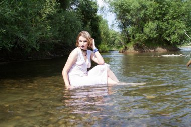 Beyaz elbiseli genç kız nehirde ısı kaçar