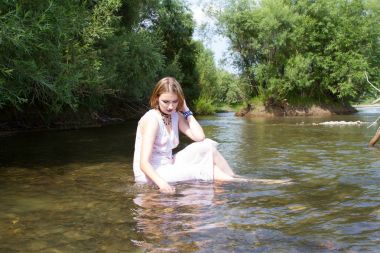 Beyaz elbiseli genç kız nehirde ısı kaçar