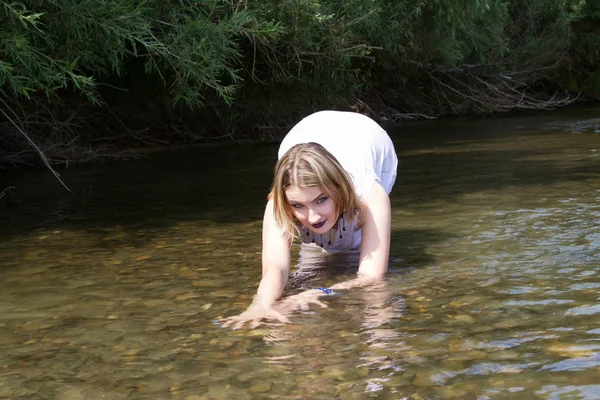 Young girl in white dress escapes from the heat in the river — Stock Photo, Image