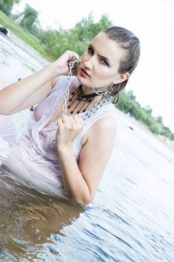 genç kız bir zincir bir nehir arka planı Zincirli