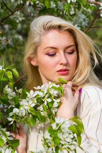 Loira no jardim entre as árvores floridas — Fotografia de Stock