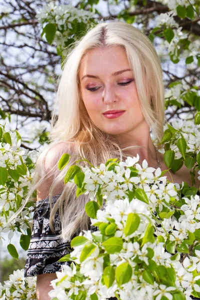 Blonde dans le jardin parmi les arbres à fleurs — Photo