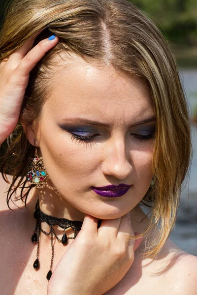 Portrait of a girl with a bright make-up on a background of juicy summer greens — Stock Photo, Image