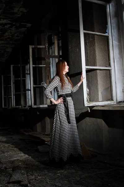 Mädchen steht am Fenster eines verlassenen Hauses — Stockfoto