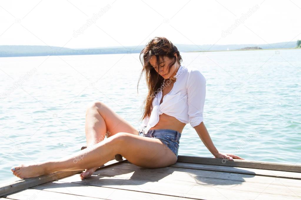 Slender girl in short shorts on the pier