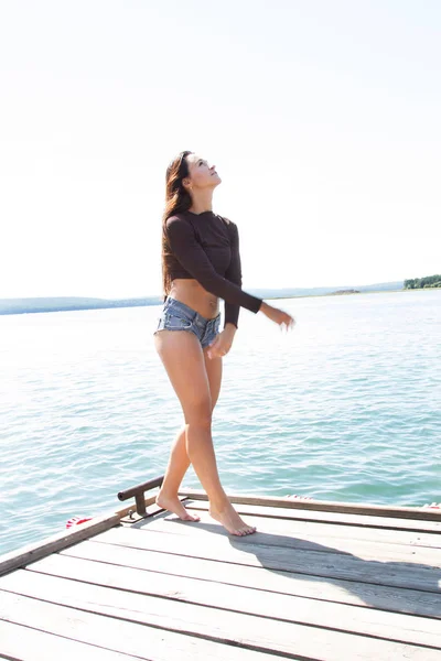Slanke meisje in korte broek op de pier — Stockfoto