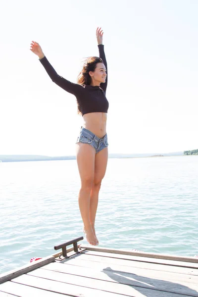 Chica delgada en pantalones cortos en el muelle — Foto de Stock