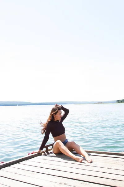 Schlankes Mädchen in kurzen Shorts auf der Seebrücke — Stockfoto