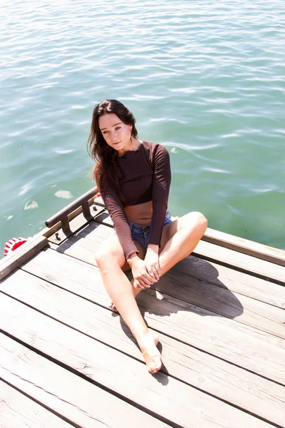 Schlankes Mädchen in kurzen Shorts auf der Seebrücke — Stockfoto