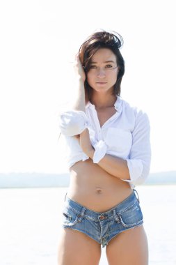 Bir kız beyaz bir gömlek ve kısa şort