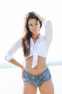 Bir kız beyaz bir gömlek ve kısa şort