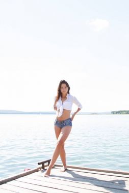 Bir kız beyaz bir gömlek ve kısa şort