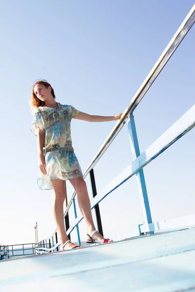 Yalnız ince kız iskelede duruyor ve denize bakar — Stok fotoğraf
