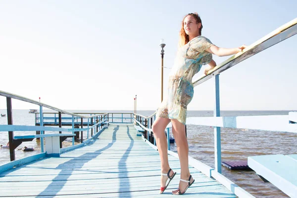 孤独なスリムな女の子は桟橋に立ち海にピア — ストック写真