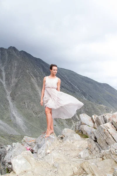 Girl in a dress on top of a mountain — Stock Photo, Image