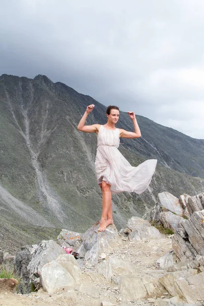 Girl in a dress on top of a mountain — Stock Photo, Image