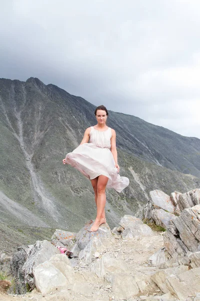 Chica en un vestido en la cima de una montaña — Foto de Stock