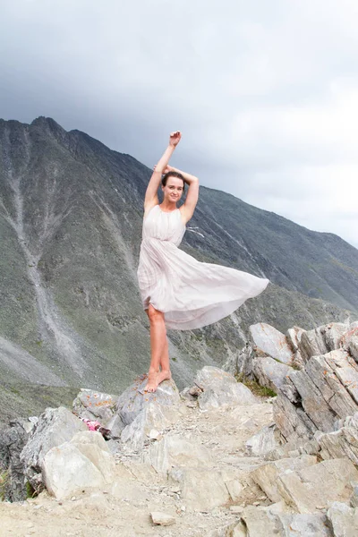 Girl in a dress on top of a mountain — Stock Photo, Image