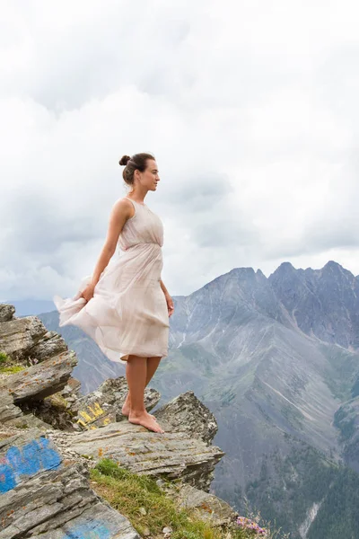 Girl in a dress on top of a mountain — Stock Photo, Image