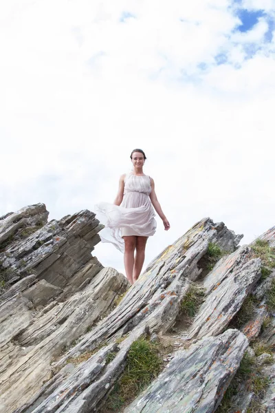 Meisje in een jurk op de top van een berg — Stockfoto