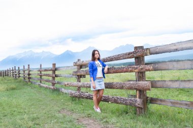 genç kız mavi ceket uzun ahşap bir çit standları