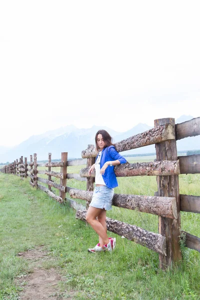 genç kız mavi ceket uzun ahşap bir çit standları