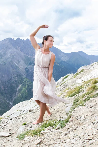 Menina em um vestido de noite no topo de um cume — Fotografia de Stock