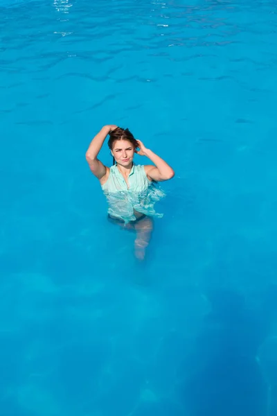 Ein Mädchen im nassen Hemd wird aus der Hitze im Pool gerettet — Stockfoto