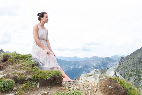 Girl in an evening dress on top of a ridge — Stock Photo, Image