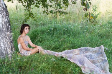 Kır çiçekleri arasında uzun elbiseli Genç kız