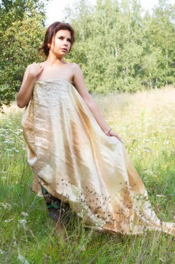 Kır çiçekleri arasında uzun elbiseli Genç kız