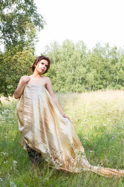 Kır çiçekleri arasında uzun elbiseli Genç kız