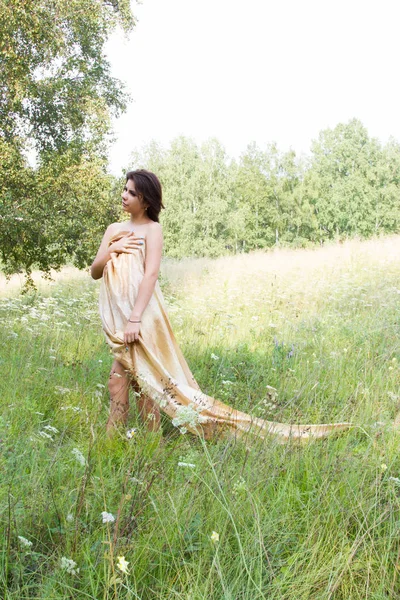 Kır çiçekleri arasında uzun elbiseli Genç kız