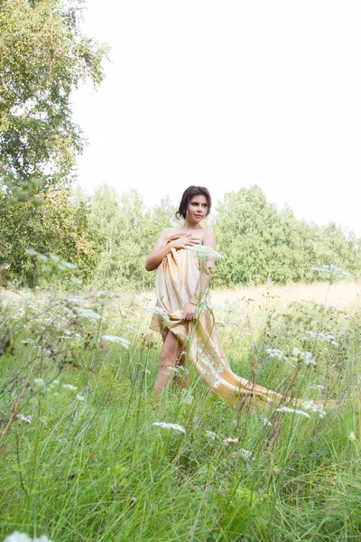 Kır çiçekleri arasında uzun elbiseli Genç kız
