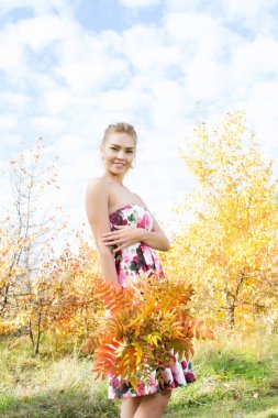 genç kız bir sonbahar ormanda yürüyor